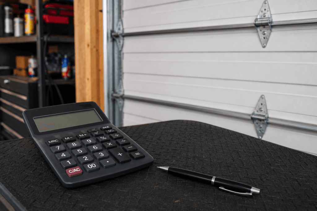 Garage door repair cost concept featuring a calculator and garage door in a residential workshop without pricing details