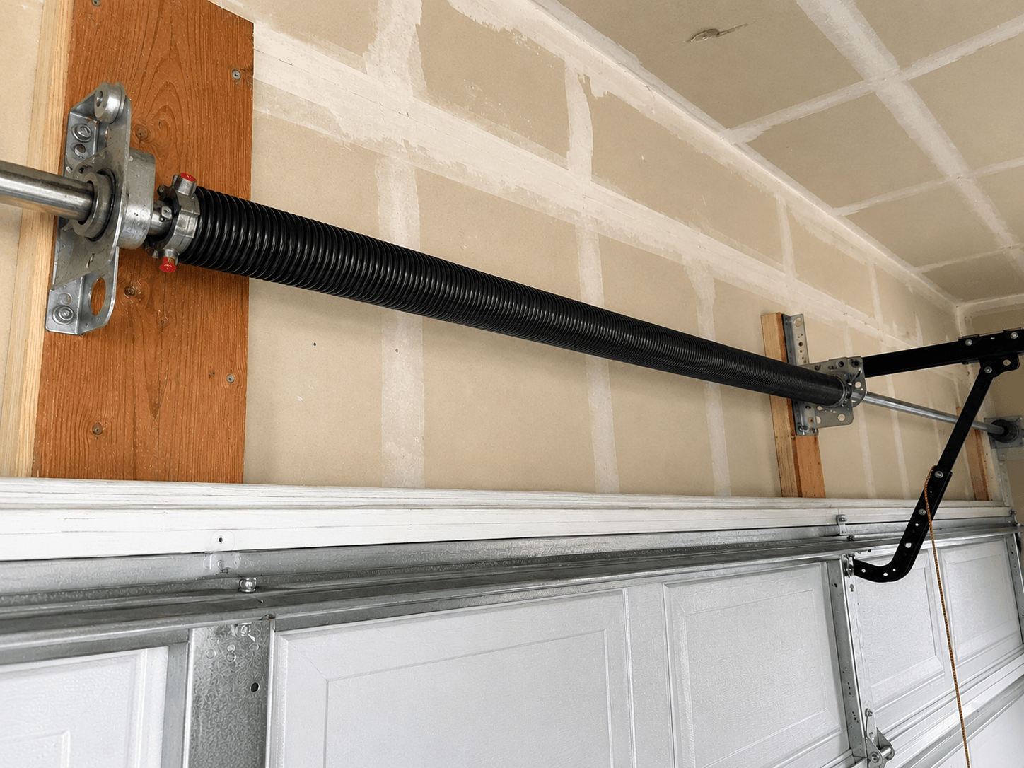 Completed garage door spring replacement with a new torsion spring restoring safe operation at a Tehaleh home