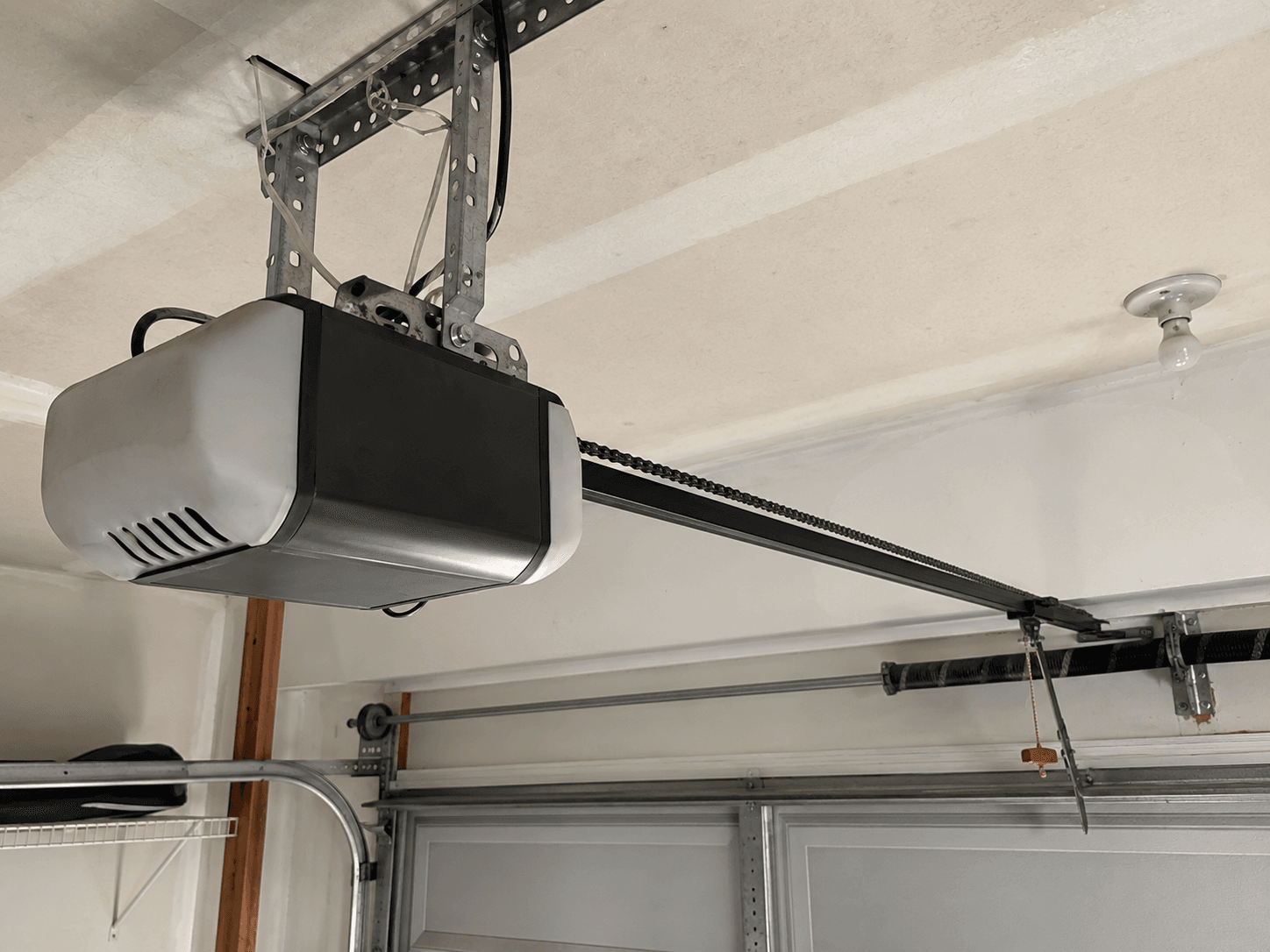 Before garage door opener upgrade showing an older chain-drive opener installed in a residential garage near Lake Tapps