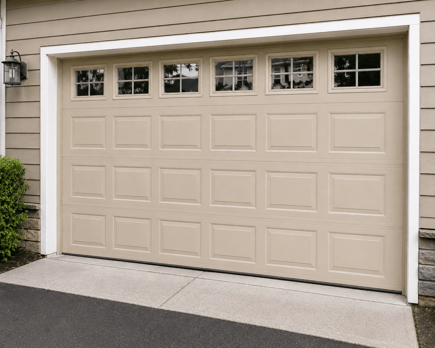 Suburban garage with tan door and green reflections