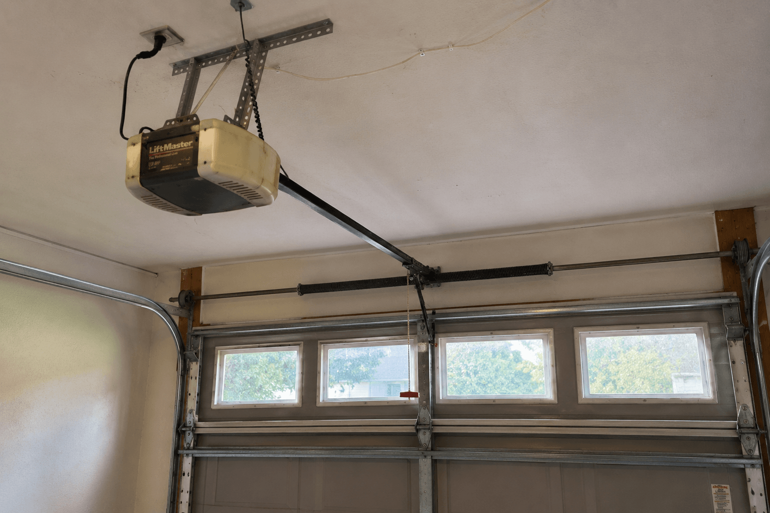 Before garage door opener replacement showing an older ceiling-mounted opener in a residential garage in Fircrest
